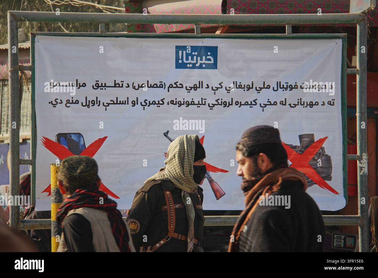 FILE - A Taliban policeman, center, and two other men walk past a ...