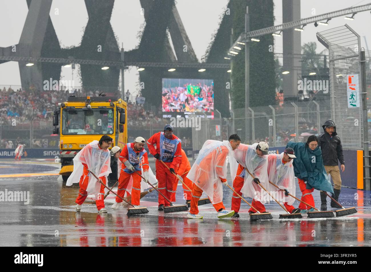Water Races Formula Workers remove water from the track as it rains before the start of the ...