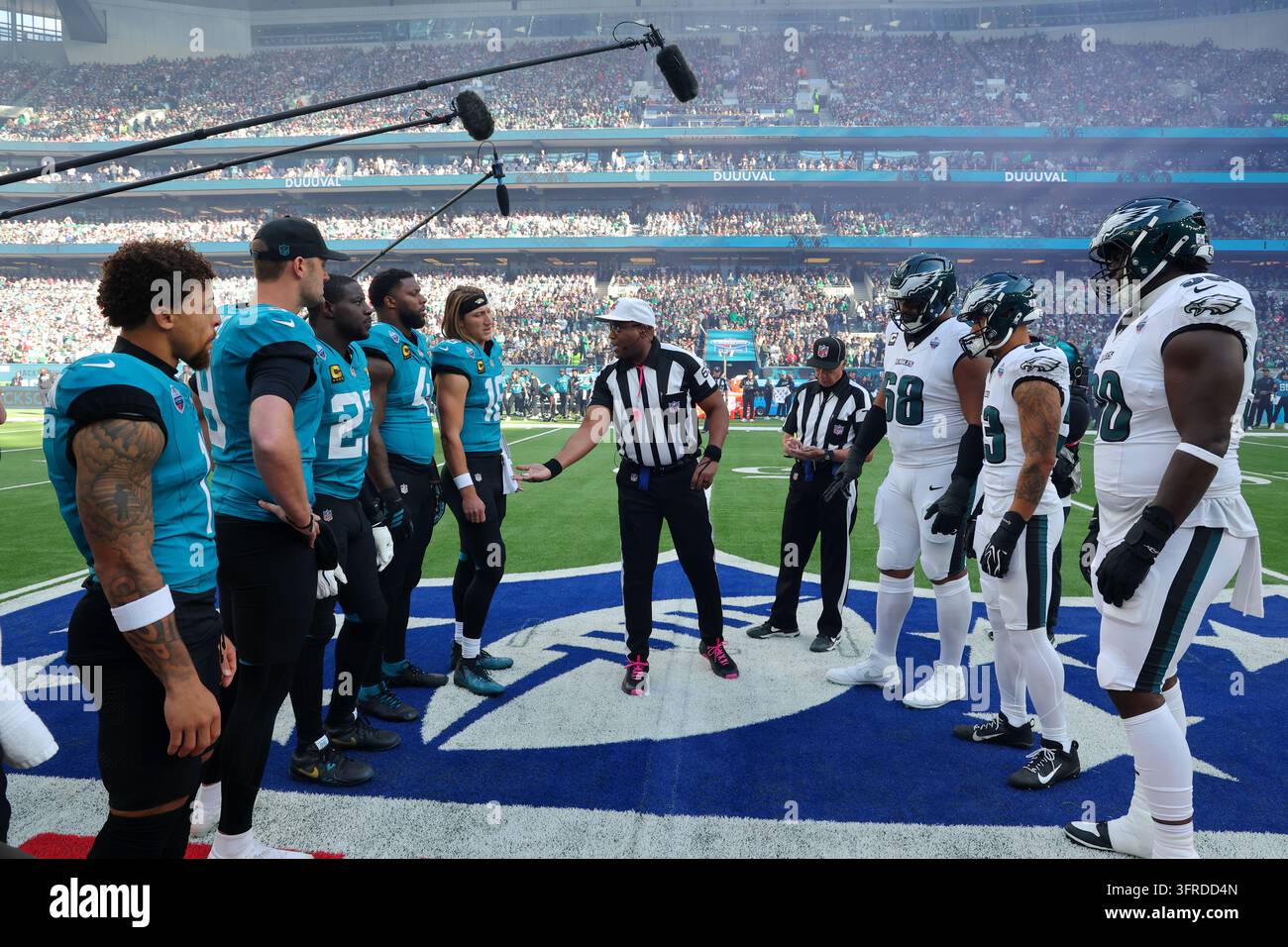 Referee Ron Torbert, center, handles the coin toss before an NFL ...