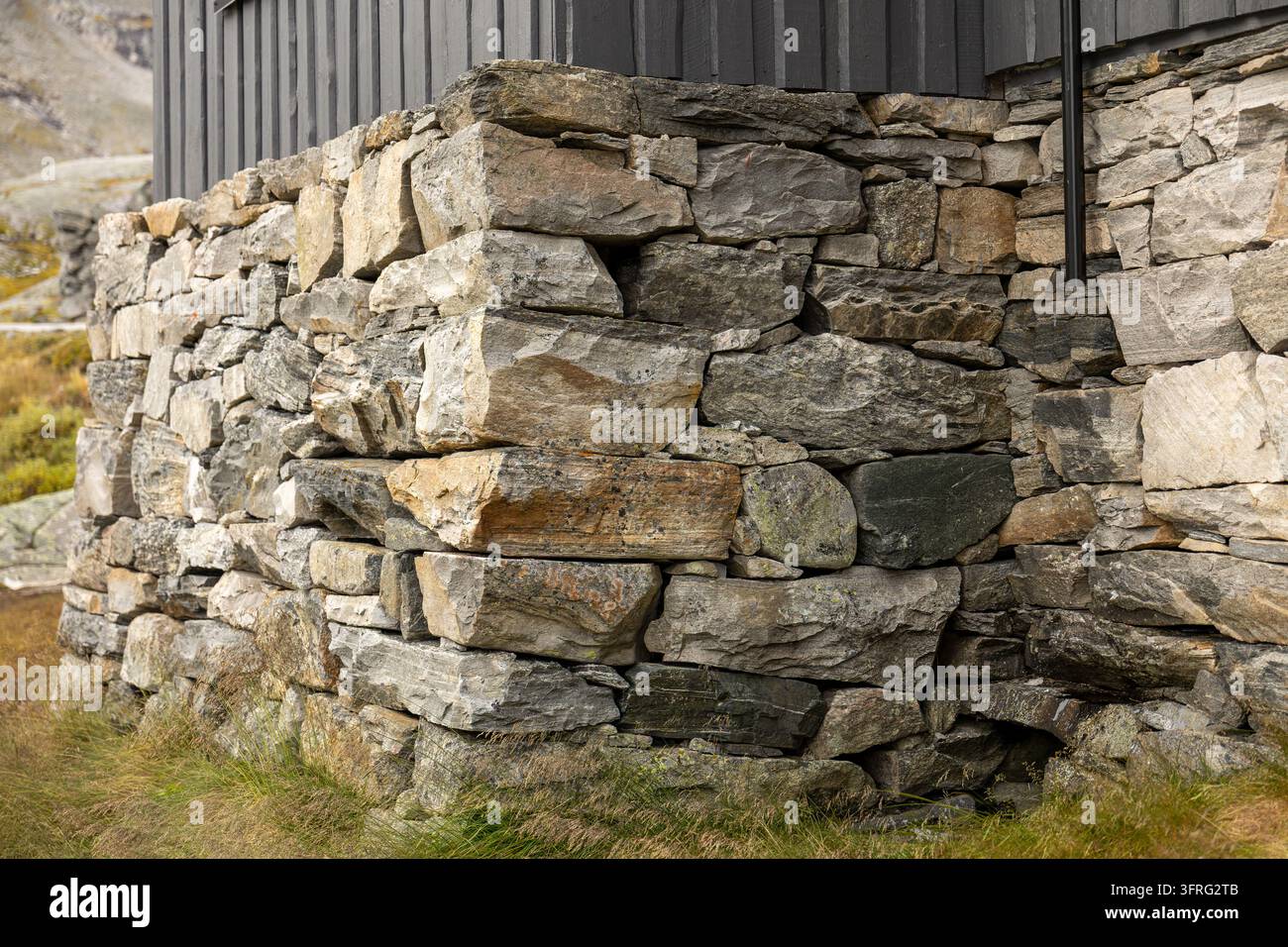 Rustic Stone Wall Built from Rough Natural Rocks and Weathered Masonry Stock Photo