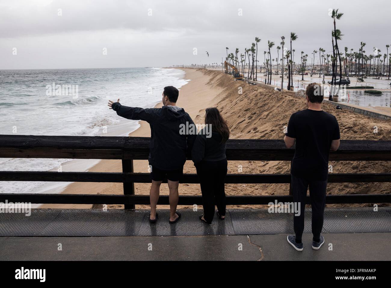 Create A Watch Onlookers watch from Balboa Pier during high tide in Newport Beach ...