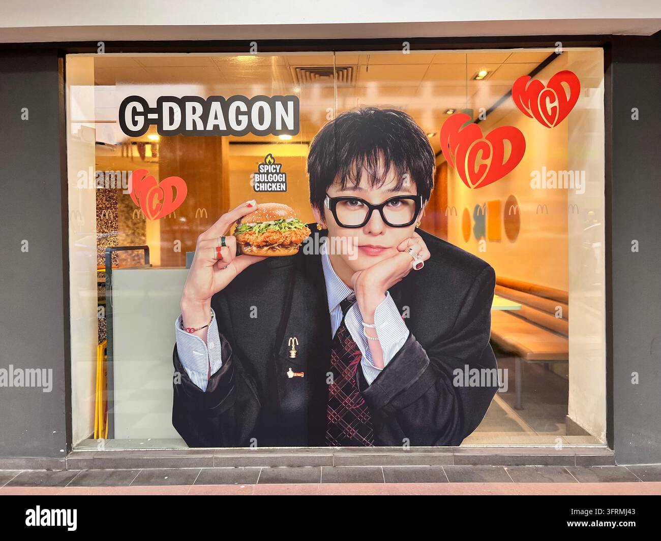 Large decal of G-dragon collaborate with MacDonald. Kwon Ji Yong is holding Spicy Bulgogi Chicken Burger. - Smartphone Captured Stock Image
