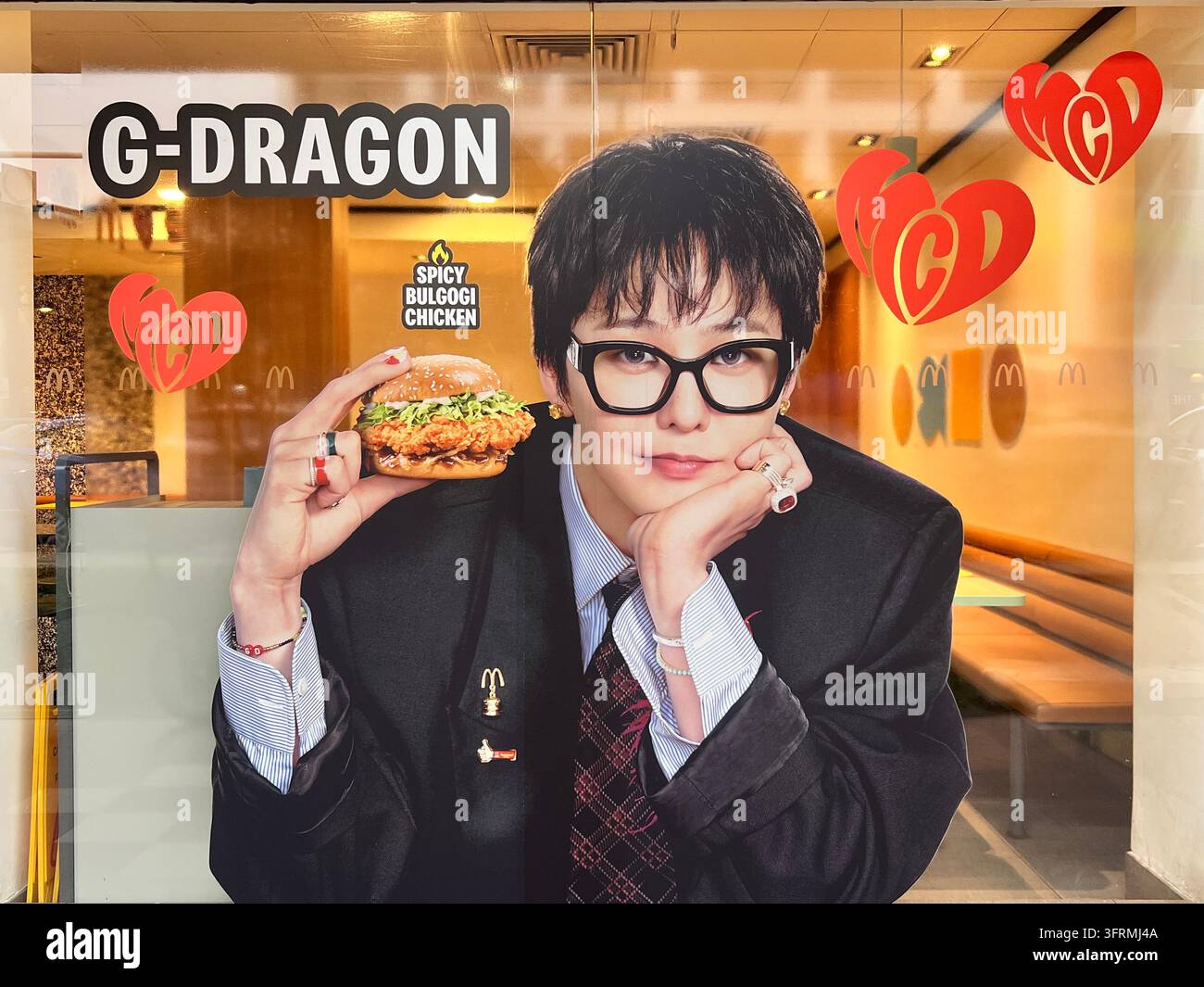 Large decal of G-dragon collaborate with MacDonald. Kwon Ji Yong is holding Spicy Bulgogi Chicken Burger. - Smartphone Captured Stock Image