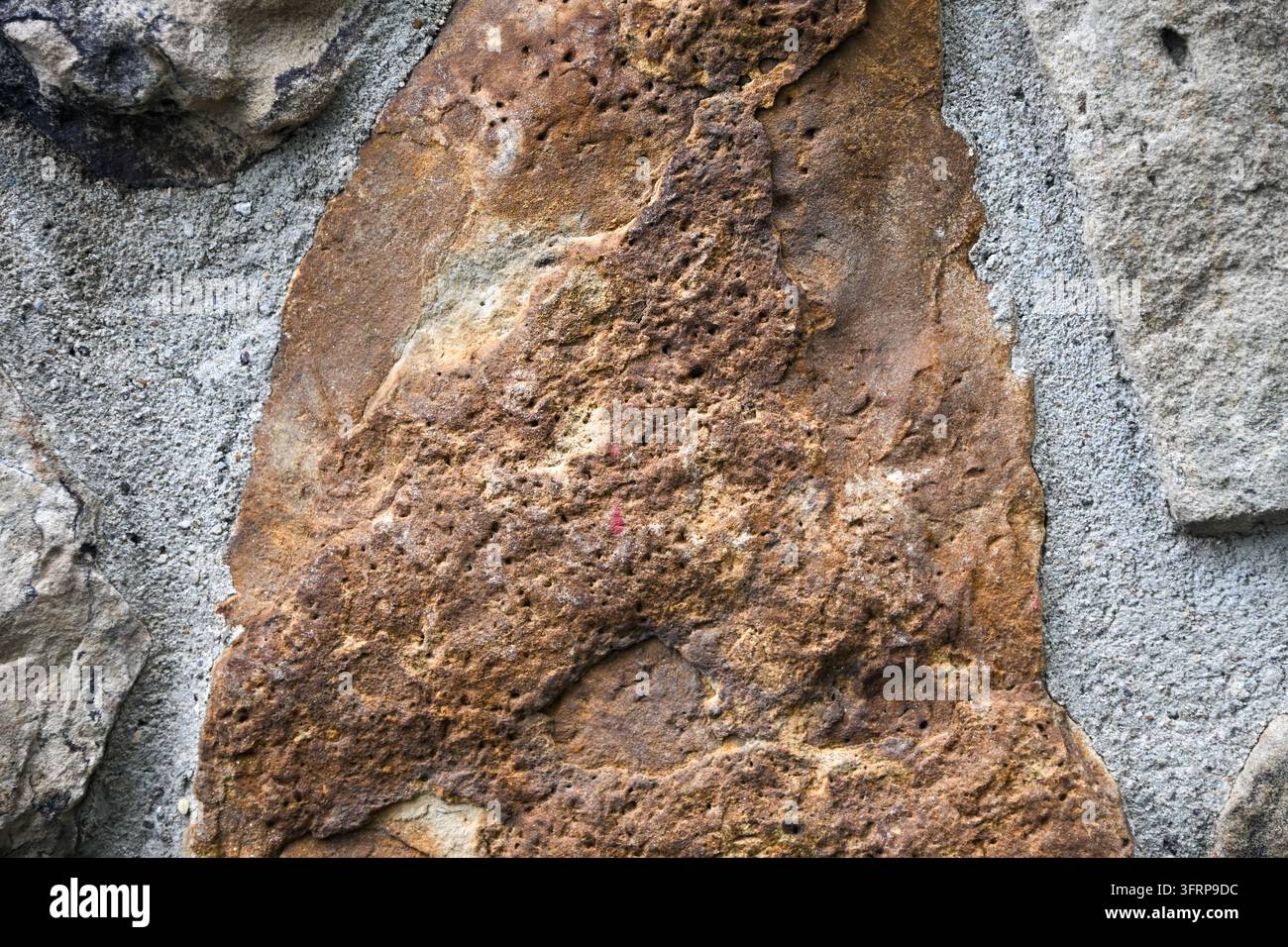 brown black and white textures on a wall surface featuring stone topography and texture Stock Photo