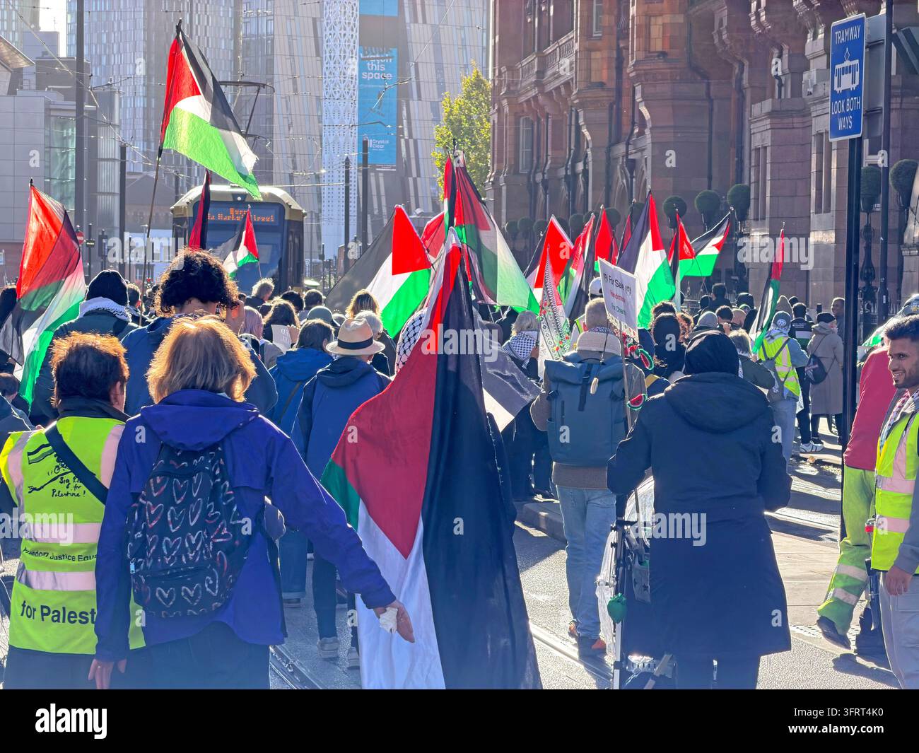 Manchester, UK, 10 Oct 2026. Pro-Palestinian demonstrators carry flags during a city-centre march towards the Bridgewater Hall, past Metrolink tram Stock Photo