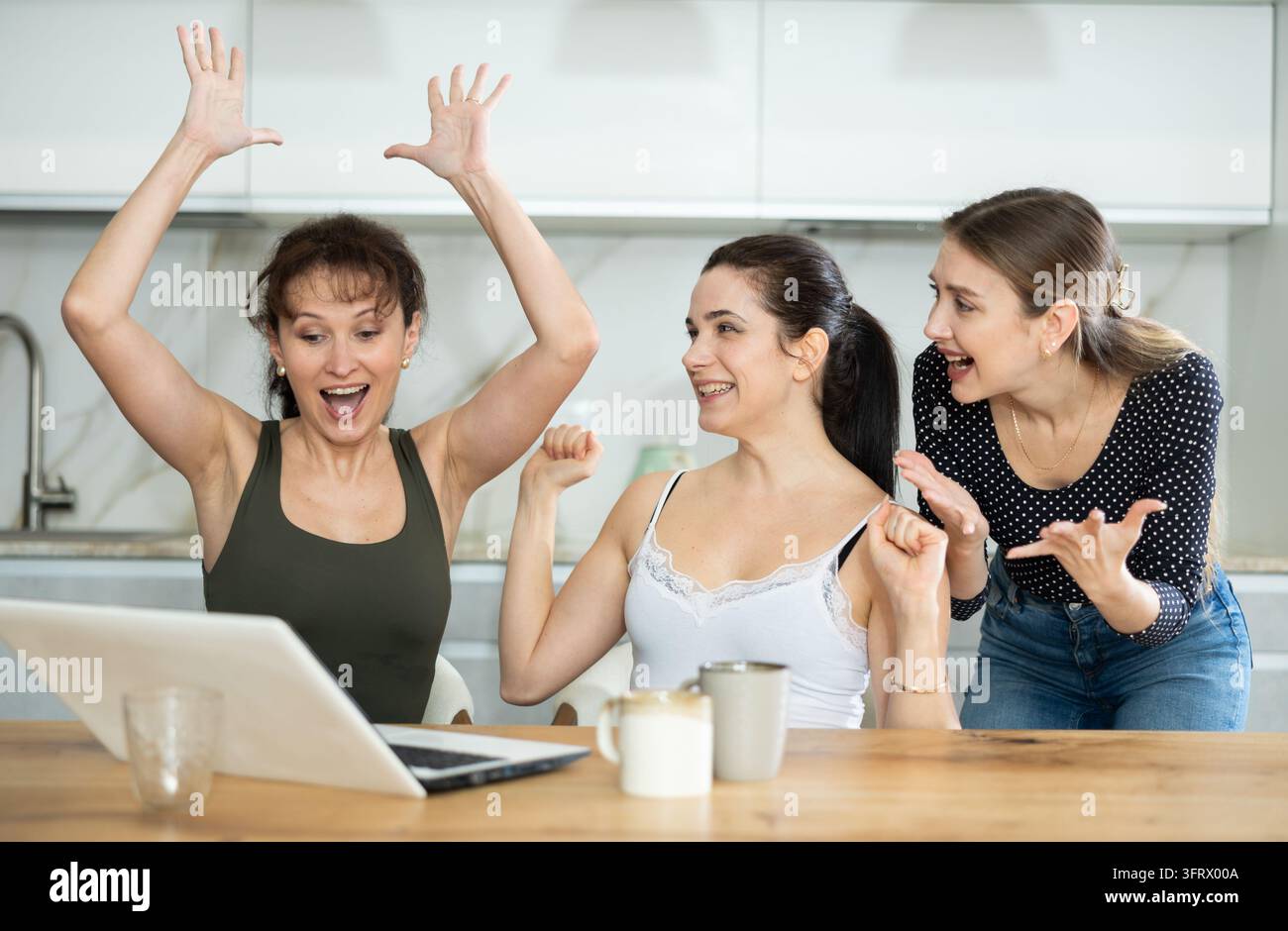 Women are sitting at computer and are immensely happy, exclaim joyfully ...