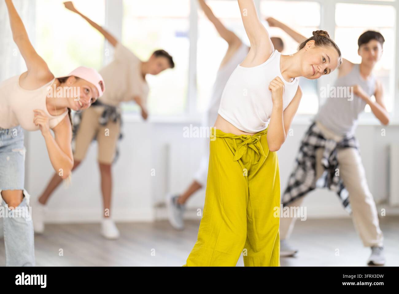During workout, teenage student girl dances hip hop with friends ...