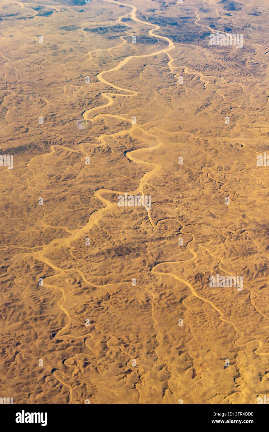 Winding Riger Aerial view of winding dry river channels carved across textured desert ...