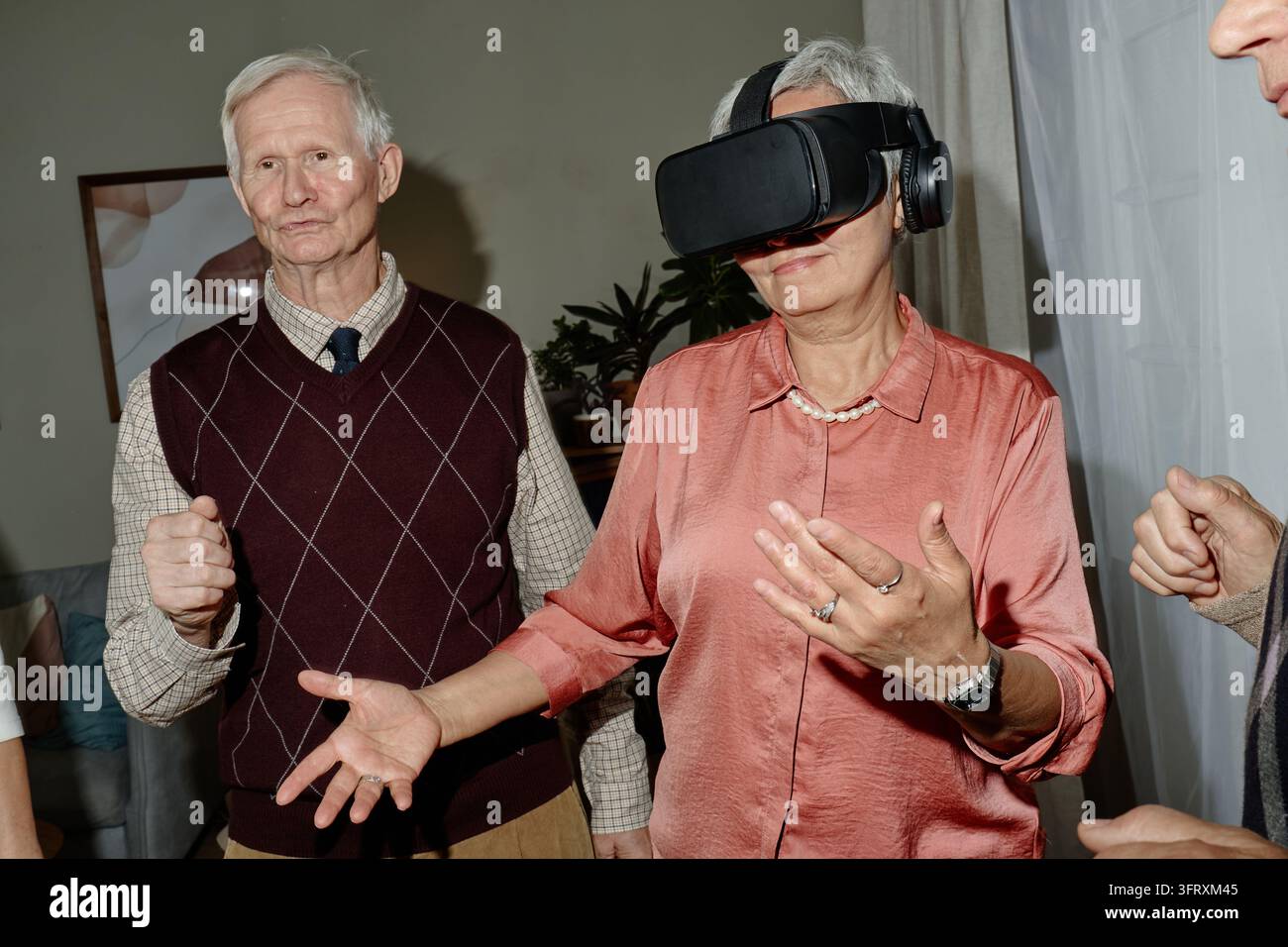 Senior Woman Using Virtual Reality Headset with Senior Man Stock Photo