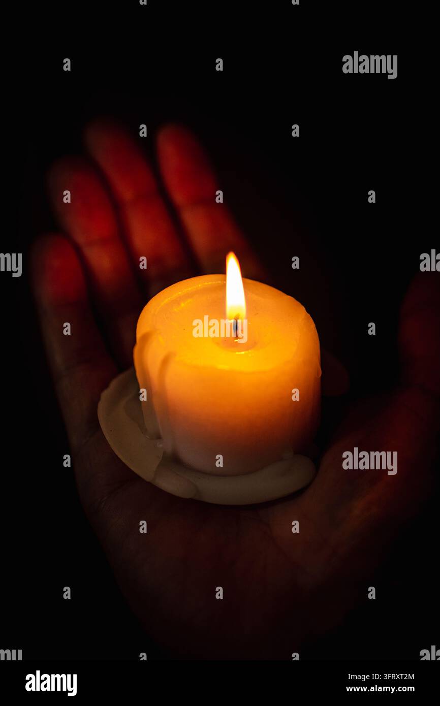 Burning candle in hands during a religious service or memorial vigil ...