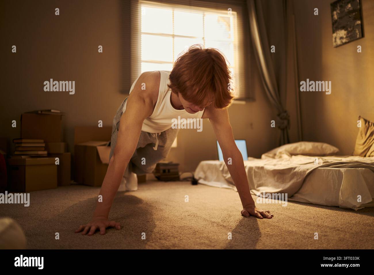 Man Doing Pushups on Floor during Morning Home Workout Stock Photo