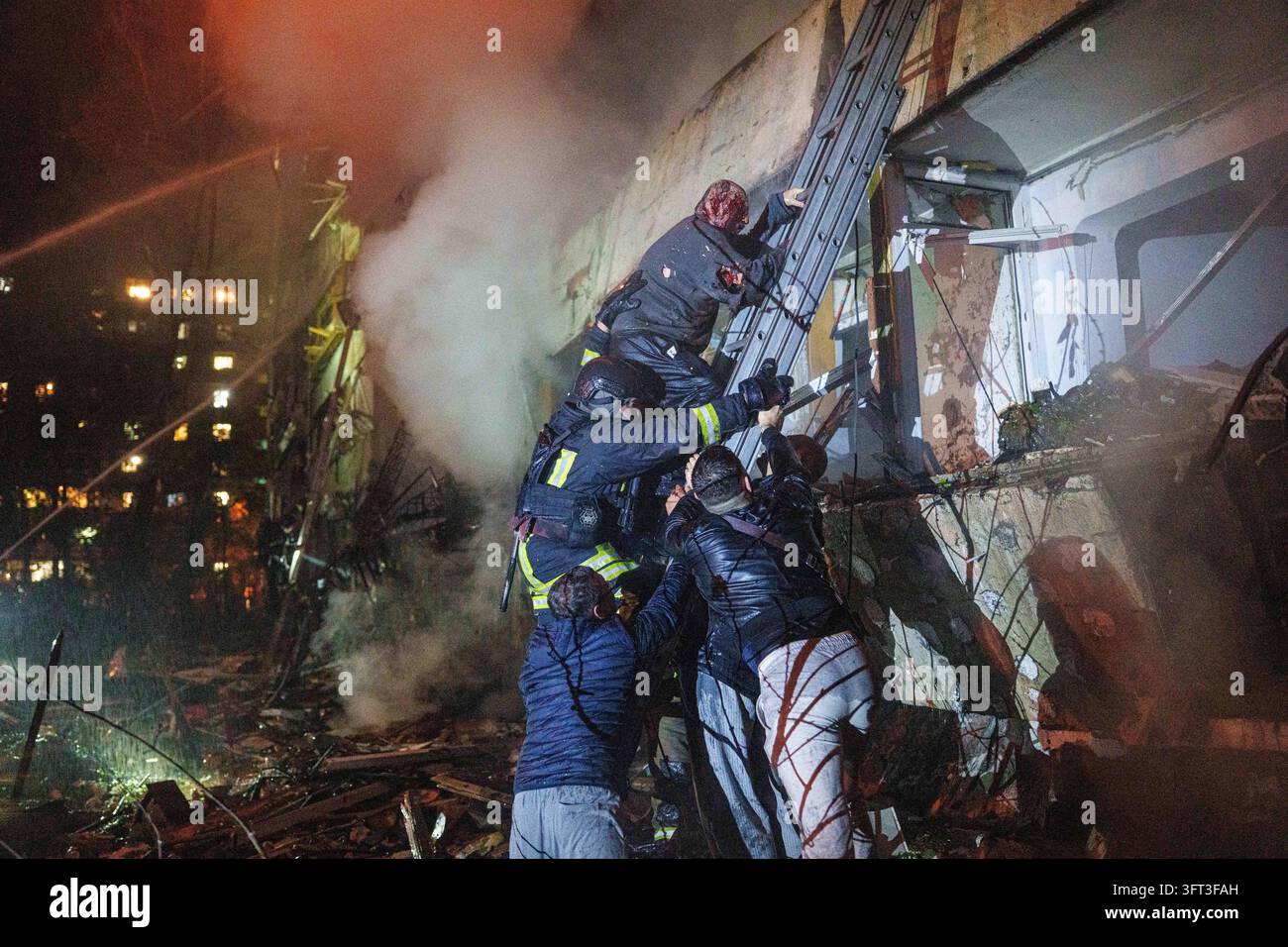 File Rescue Software Rescue workers help Leonid, an injured resident, down a ladder from his ...