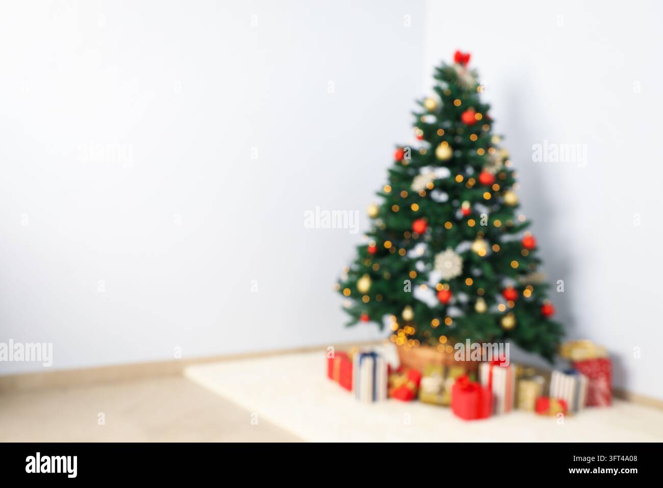 Christmas tree with garland and gift boxes in room, blurred background ...