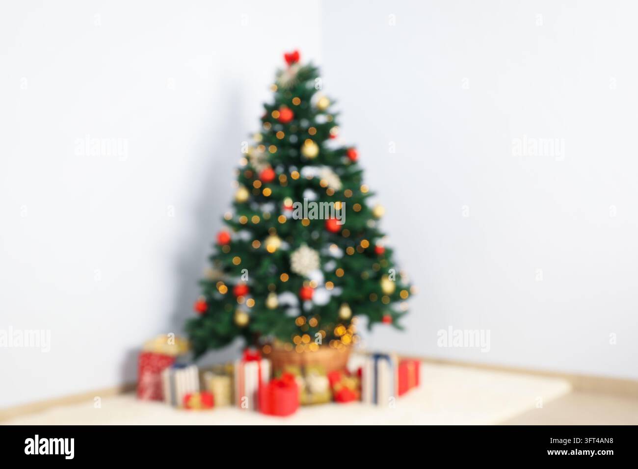 Christmas tree with garland and gift boxes in room, blurred background ...