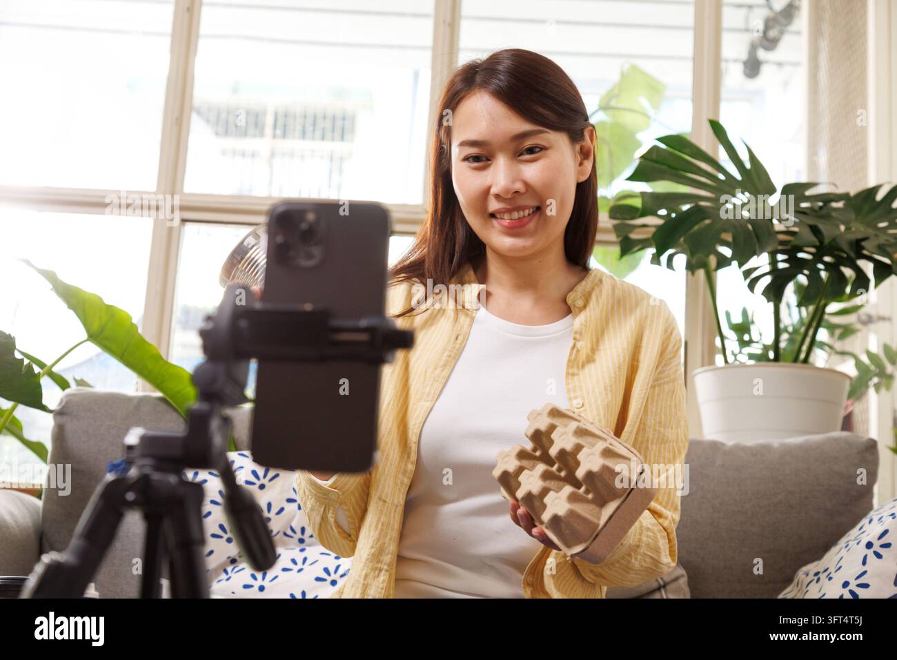 Asian female content creator recording video with smartphone ...