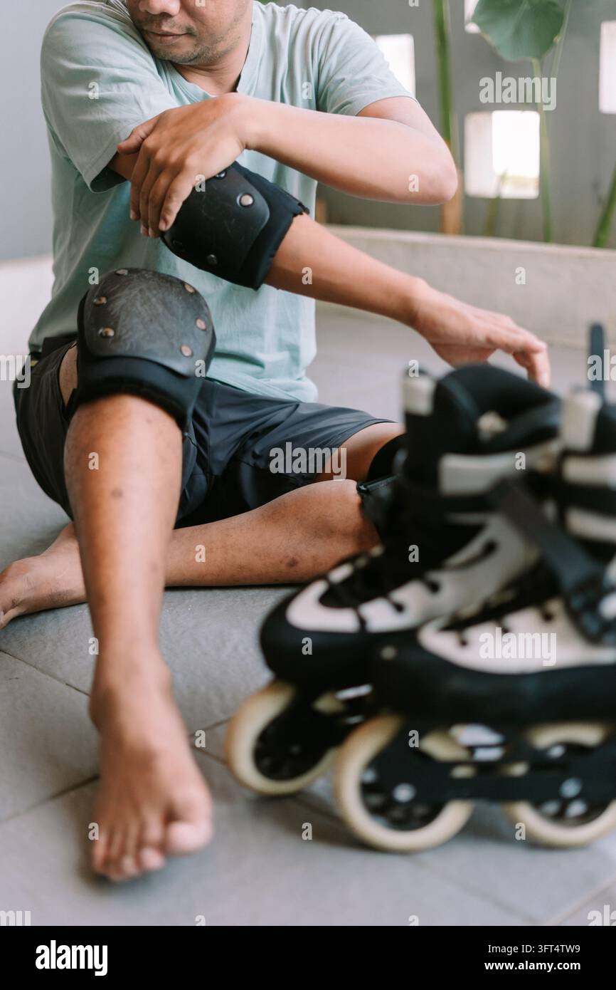 Person sitting on the ground adjusting elbow and knee pads before ...