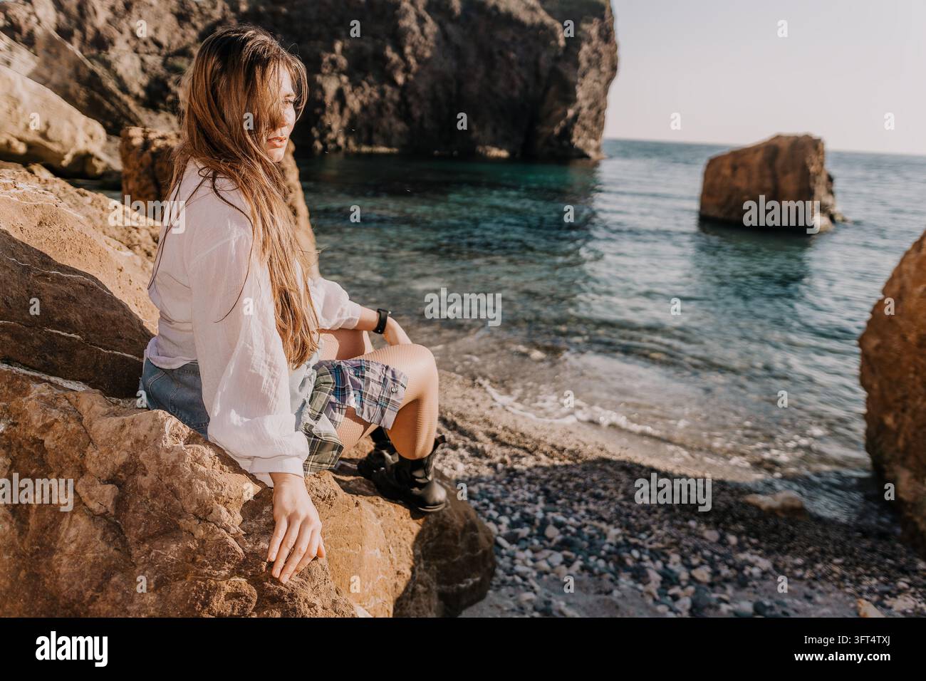 Beautiful young woman with long hair wearing a white shirt and boots ...
