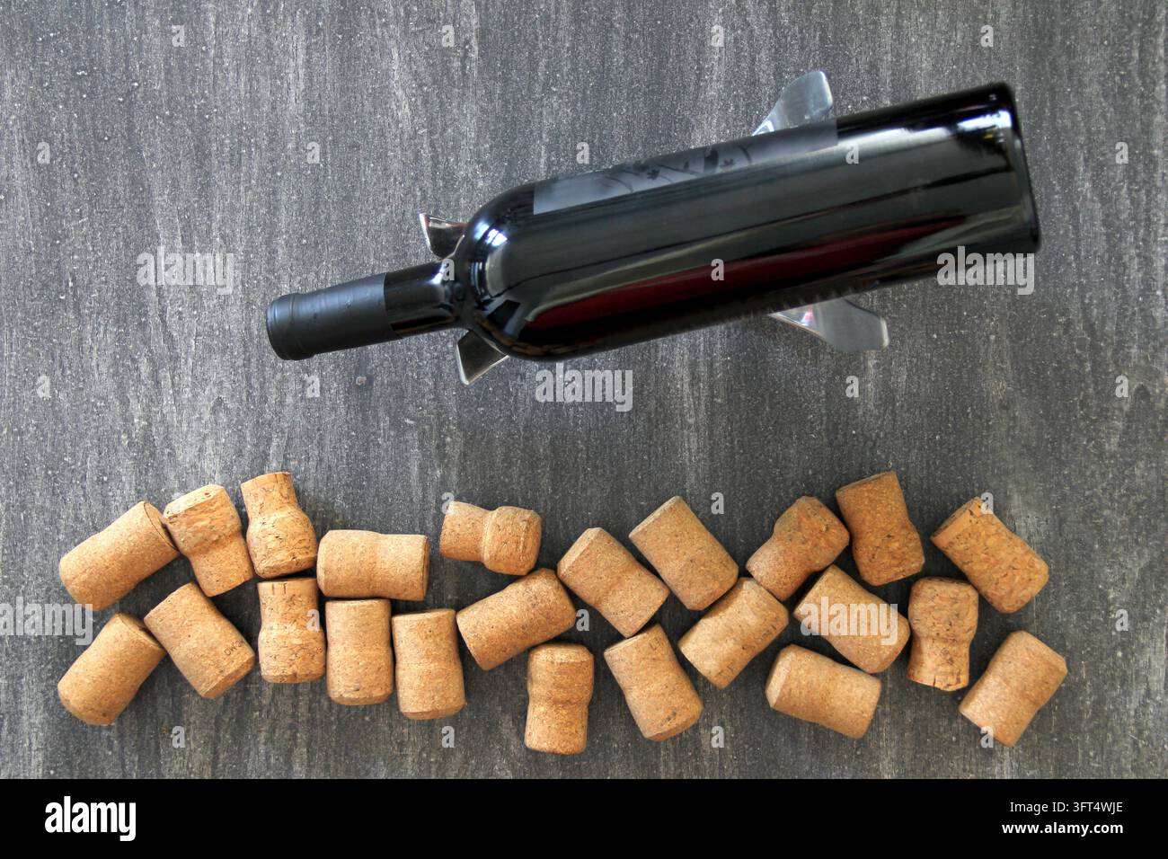 Black bottle of red wine with multiple corks on abstract vintage gray ...