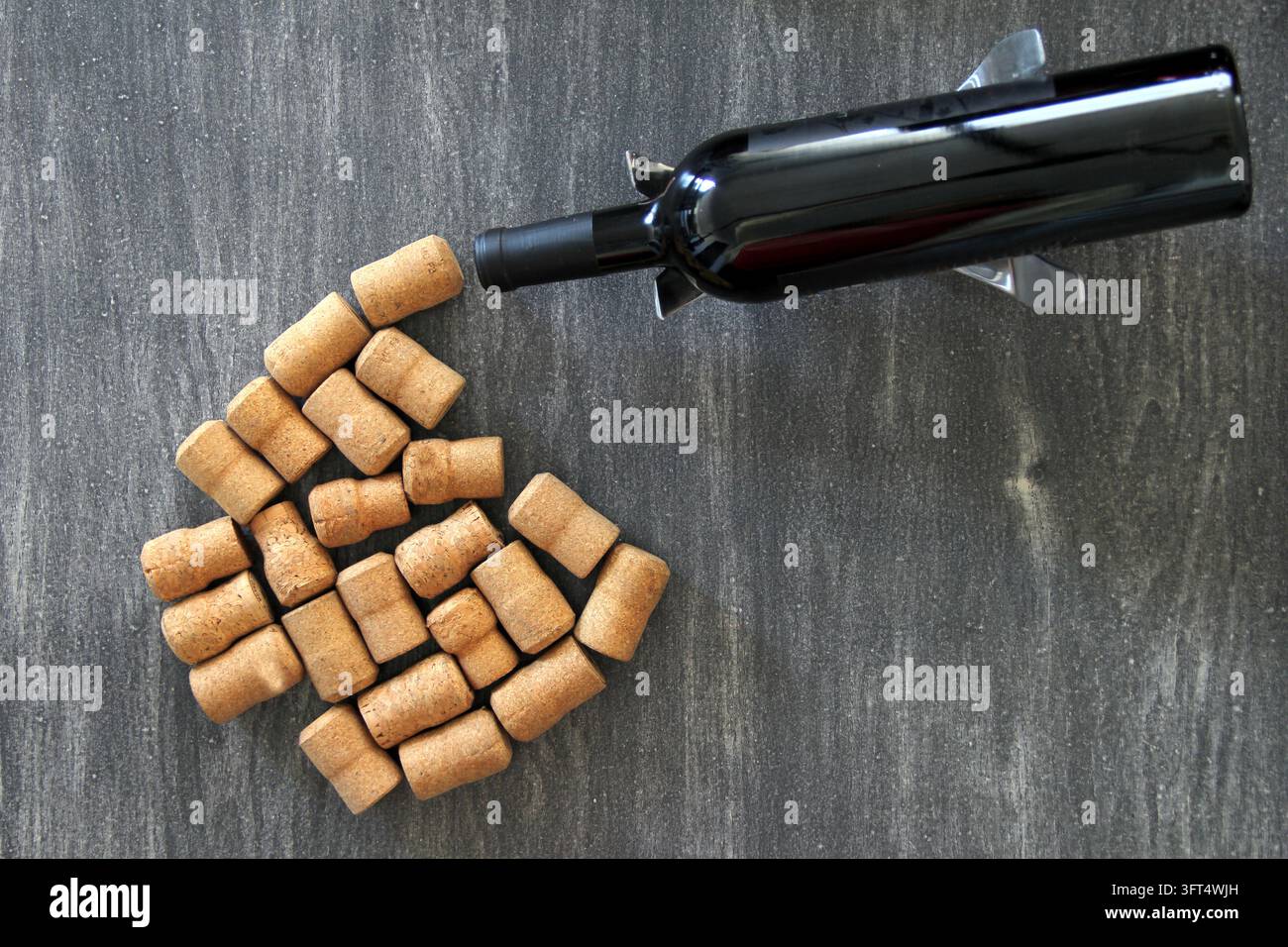 Black bottle of red wine with multiple corks on abstract vintage gray ...