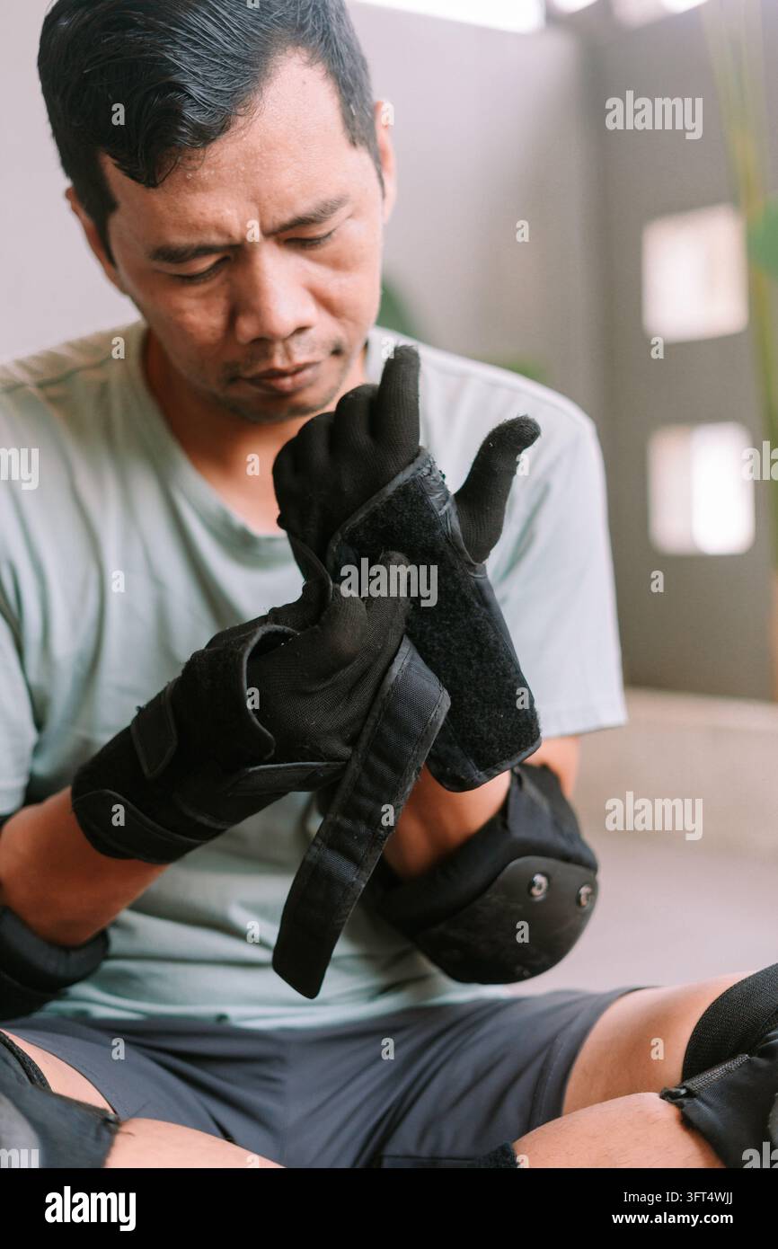 A person preparing for inline skating by securing black protective ...