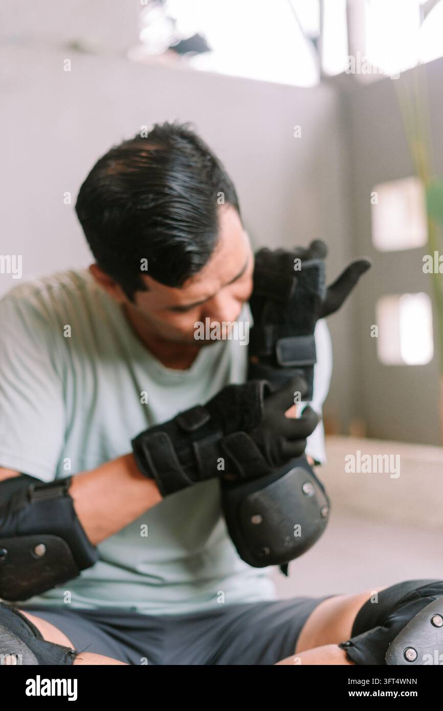 An individual adjusts protective wrist guards and pads before inline ...