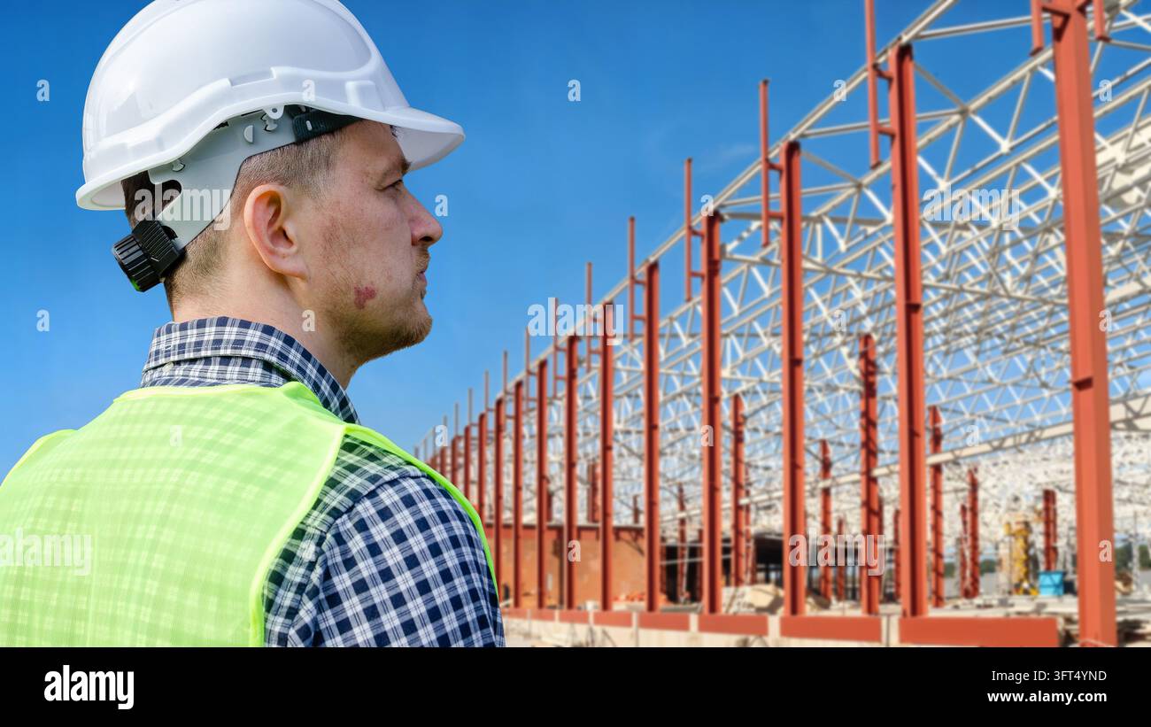 Wearing a hard hat and high-visibility vest, he inspects rising red ...