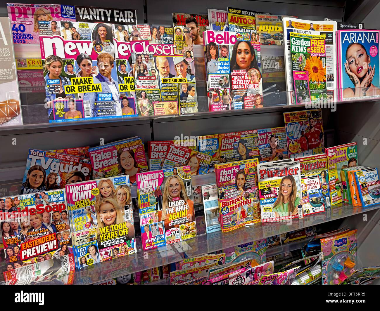 Colourful women's magazines and celebrity weeklies on a UK newsagent's display shelf. Stock Photo