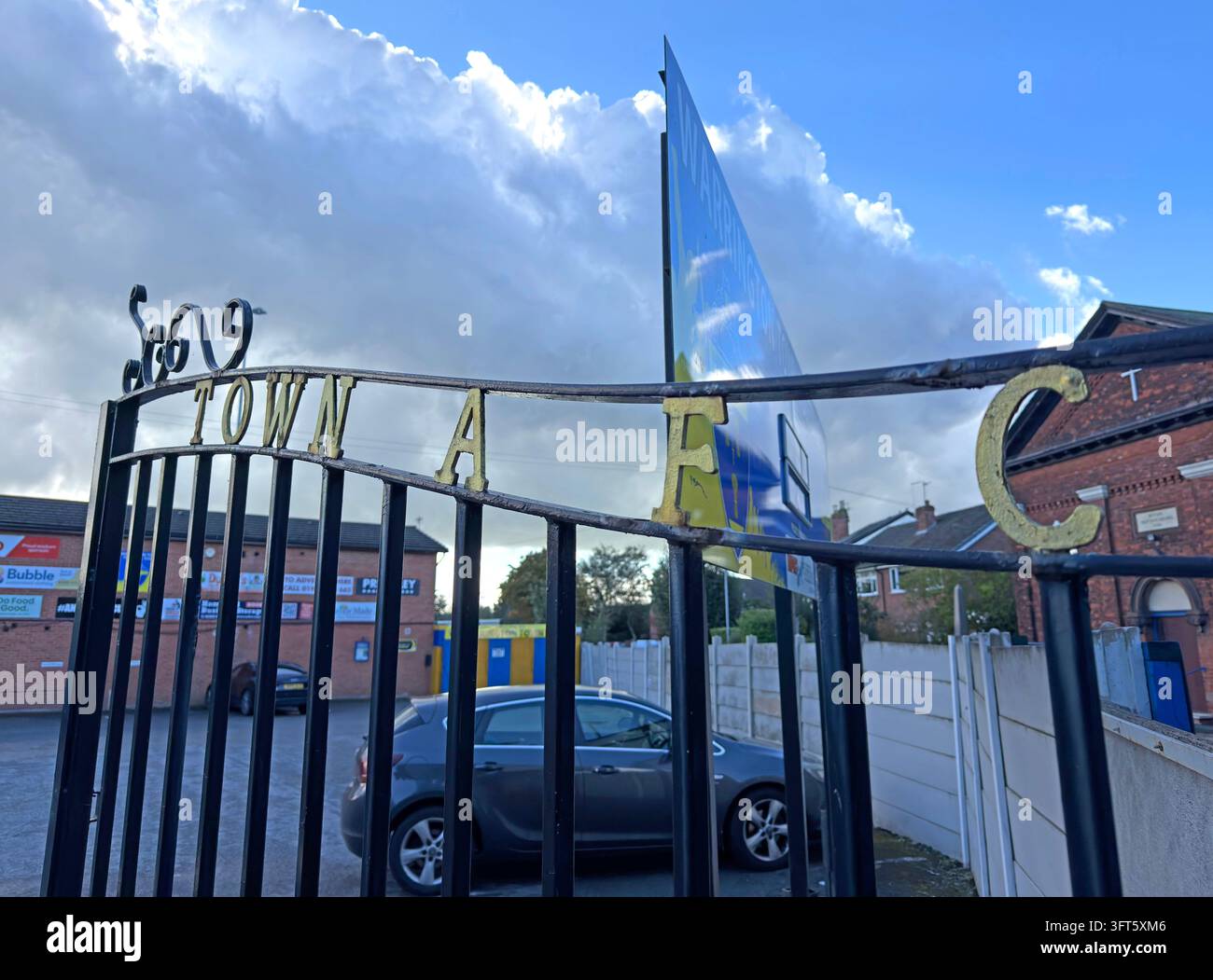 Warrington Town FC flags flutter above the entrance gates of Cantilever Park football ground. Stock Photo