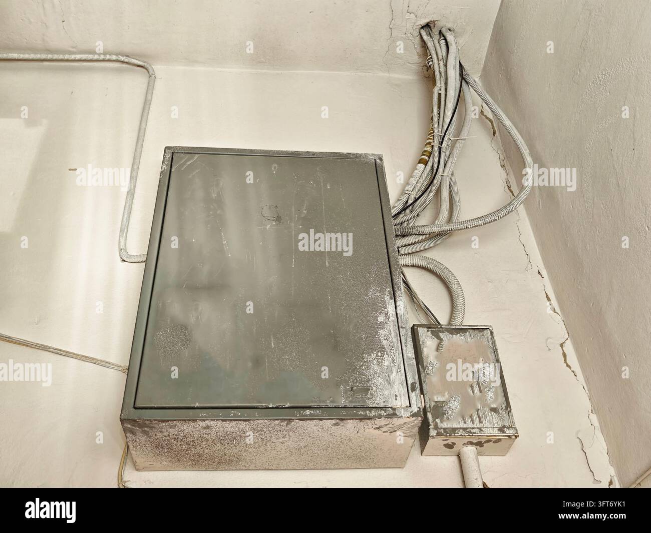 Dusty metal electrical distribution box with visible cables near a ...