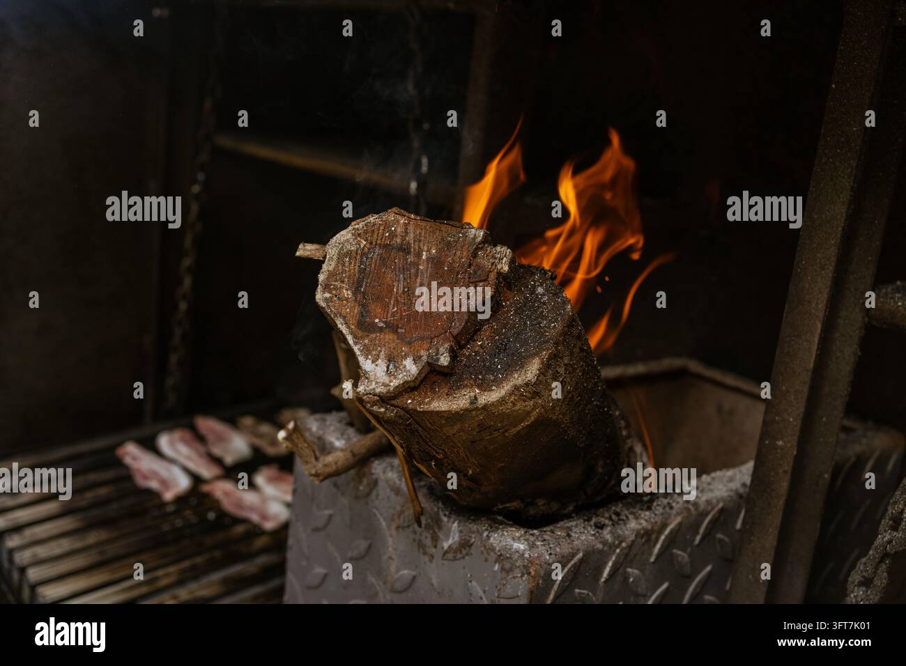 Burning Log in a Barbecue with Glowing Embers and Flames Stock Photo
