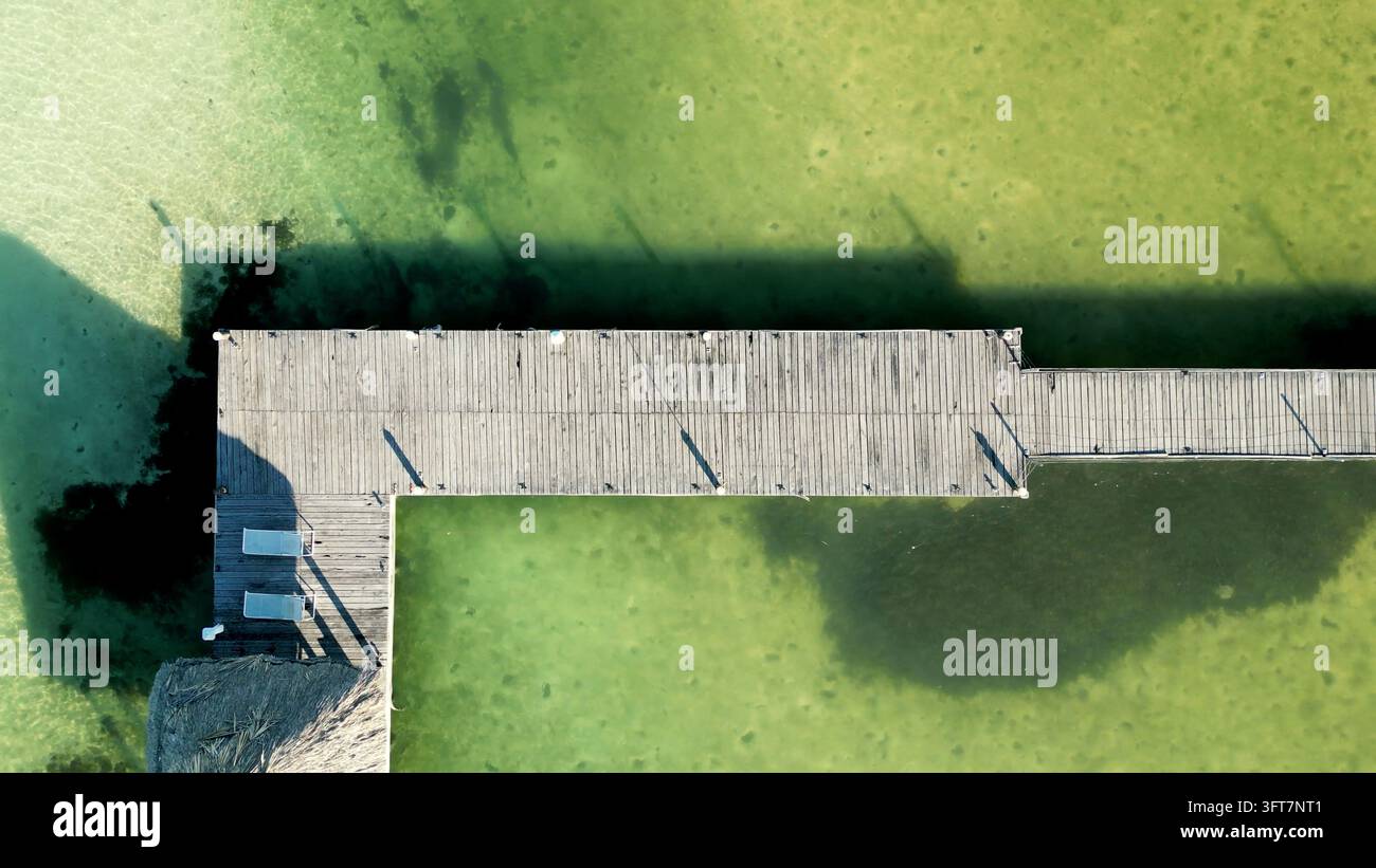 Aerial view of an angular wooden pier corner and its dark shadow ...