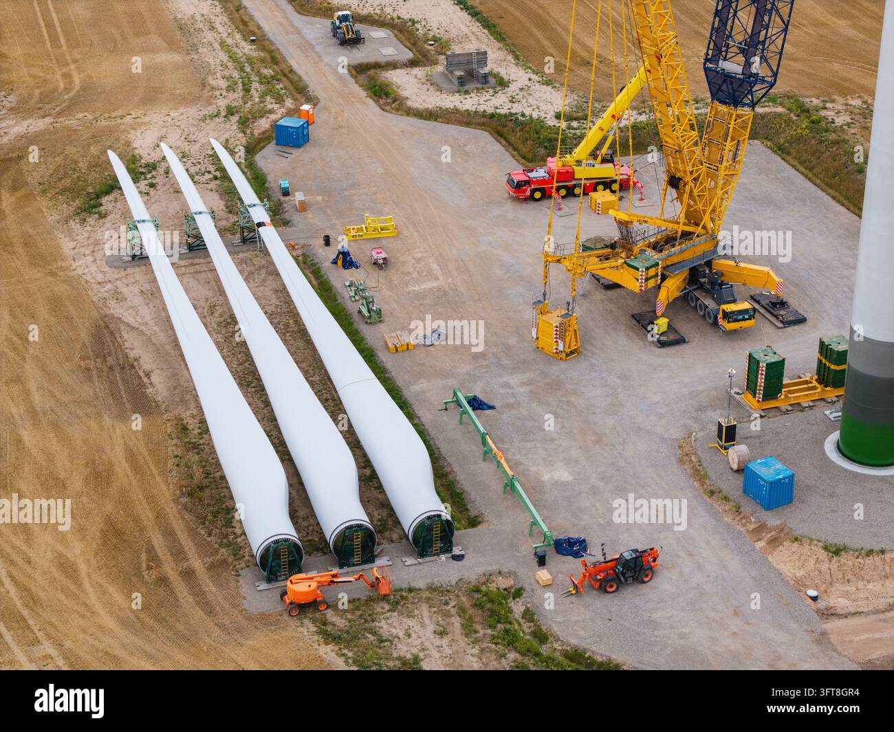 Aerial view of wind turbine blades laid out on the ground next to a ...
