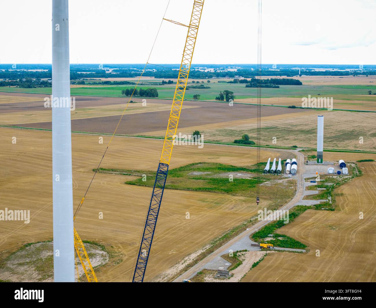 Aerial view of wind turbine construction site featuring a tall crane ...