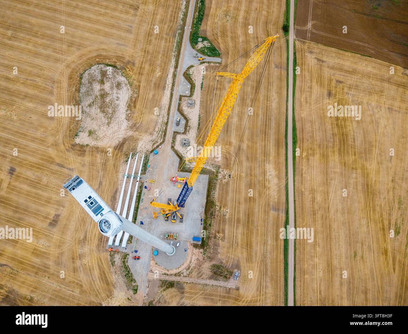 Aerial view of a wind turbine under construction with a large yellow ...