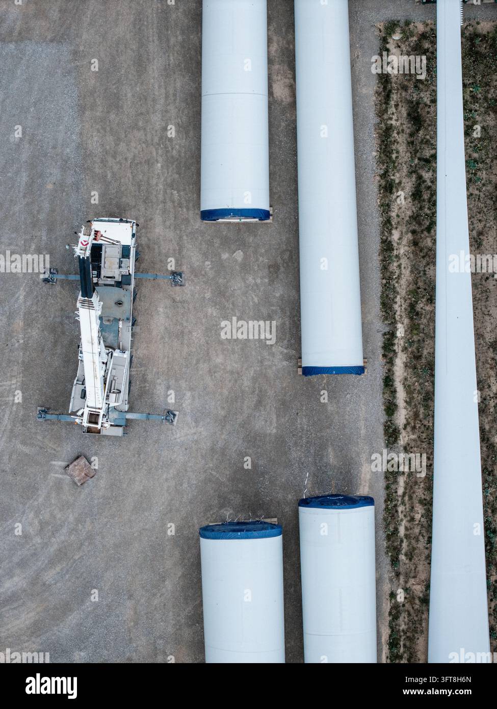 Aerial view of wind turbine tower sections and a long rotor blade being ...