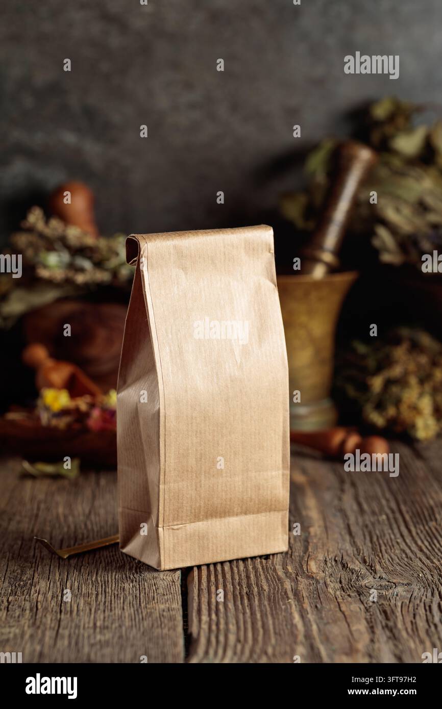 A tall brown paper bag on an old wooden table. Packaging for herbal tea ...