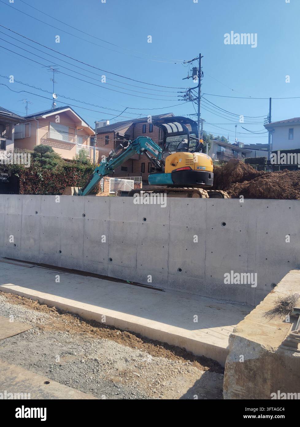 Excavator at a building demolition site in a residential area of Tokyo, Japan. - Smartphone Captured Stock Image