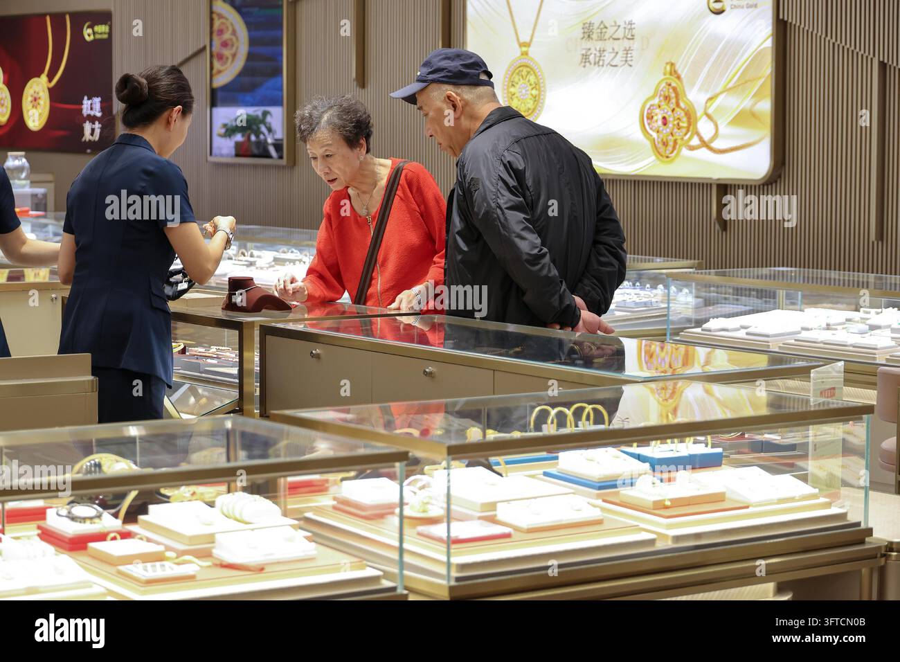 Gold Rong's Customers select gold jewelry at a mall counter in Shanghai, east China ...