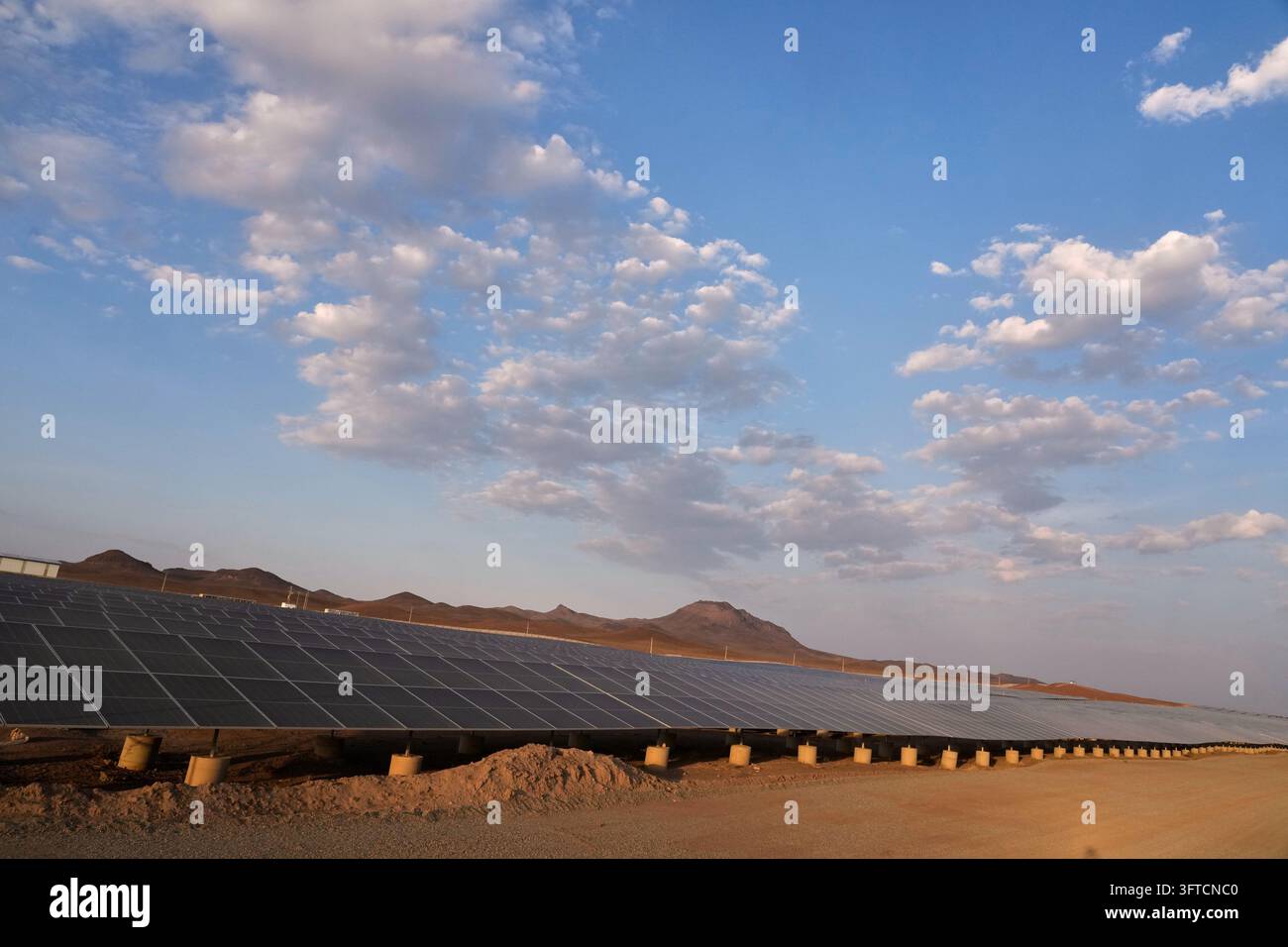 Back Outside Solar panels stand at a solar power plant connected to Iran's national ...