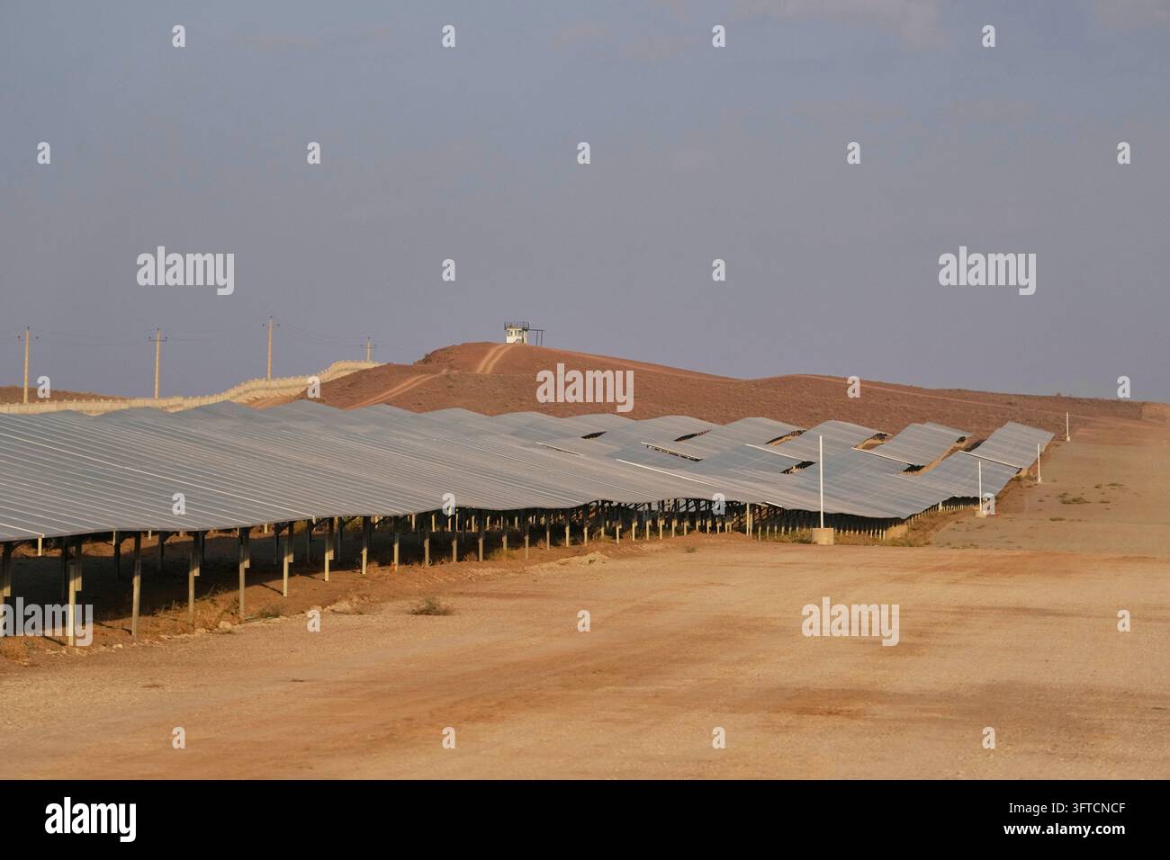 Back Outside Solar panels stand at a solar power plant connected to Iran's national ...