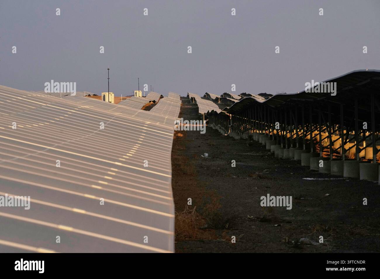 Back Outside Solar panels stand at a solar power plant connected to Iran's national ...