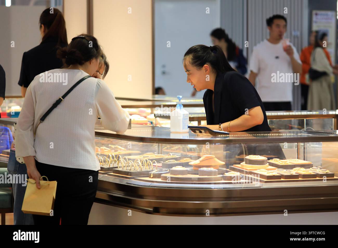 Gold Rong's Customers select gold jewelry at a brand store in Huai'an, east China's ...