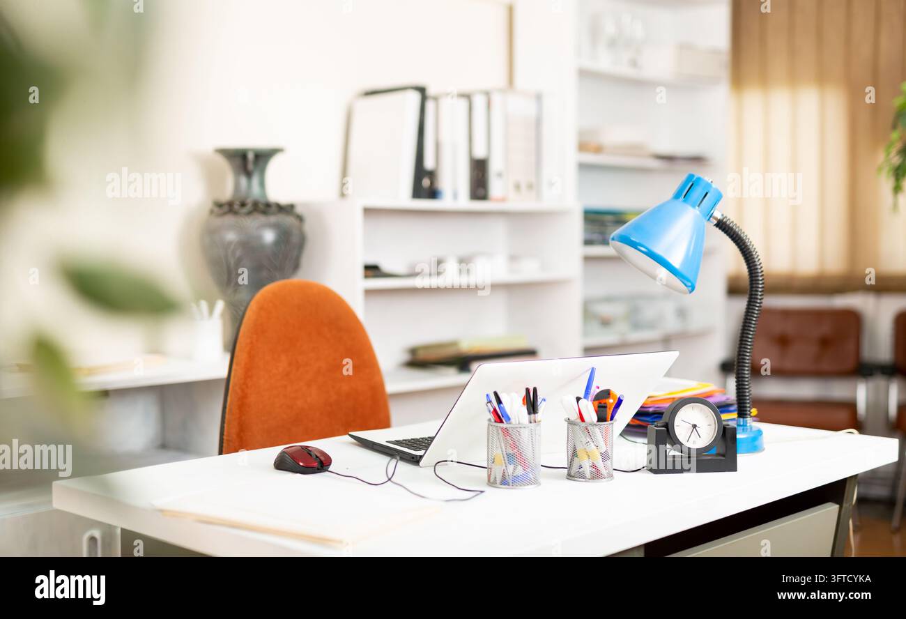 Comfortable workplace desk for businessman with laptop in white modern office interior Stock Photo
