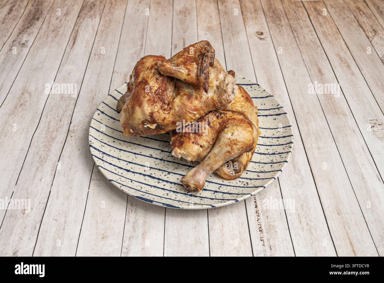 Golden roasted chicken with crispy browned skin, cut into pieces and ...