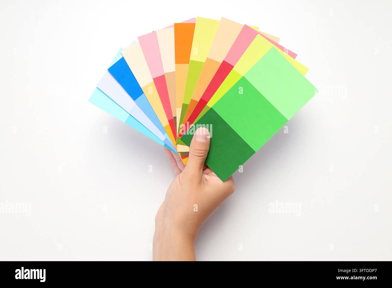 Female hand holding color palettes on white background Stock Photo - Alamy