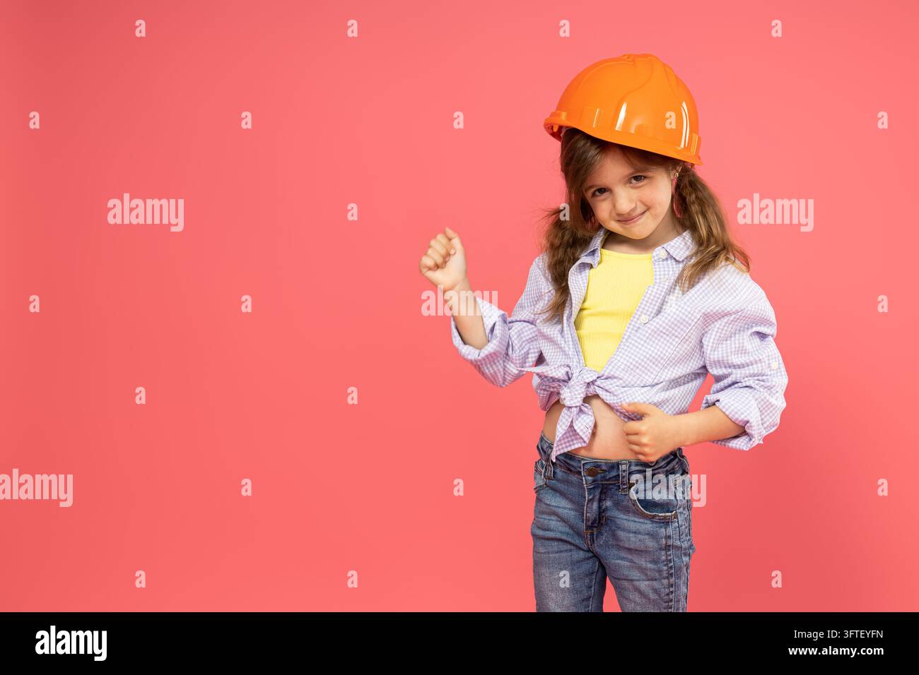 Little girl in construction helmet on pink background, place for text ...