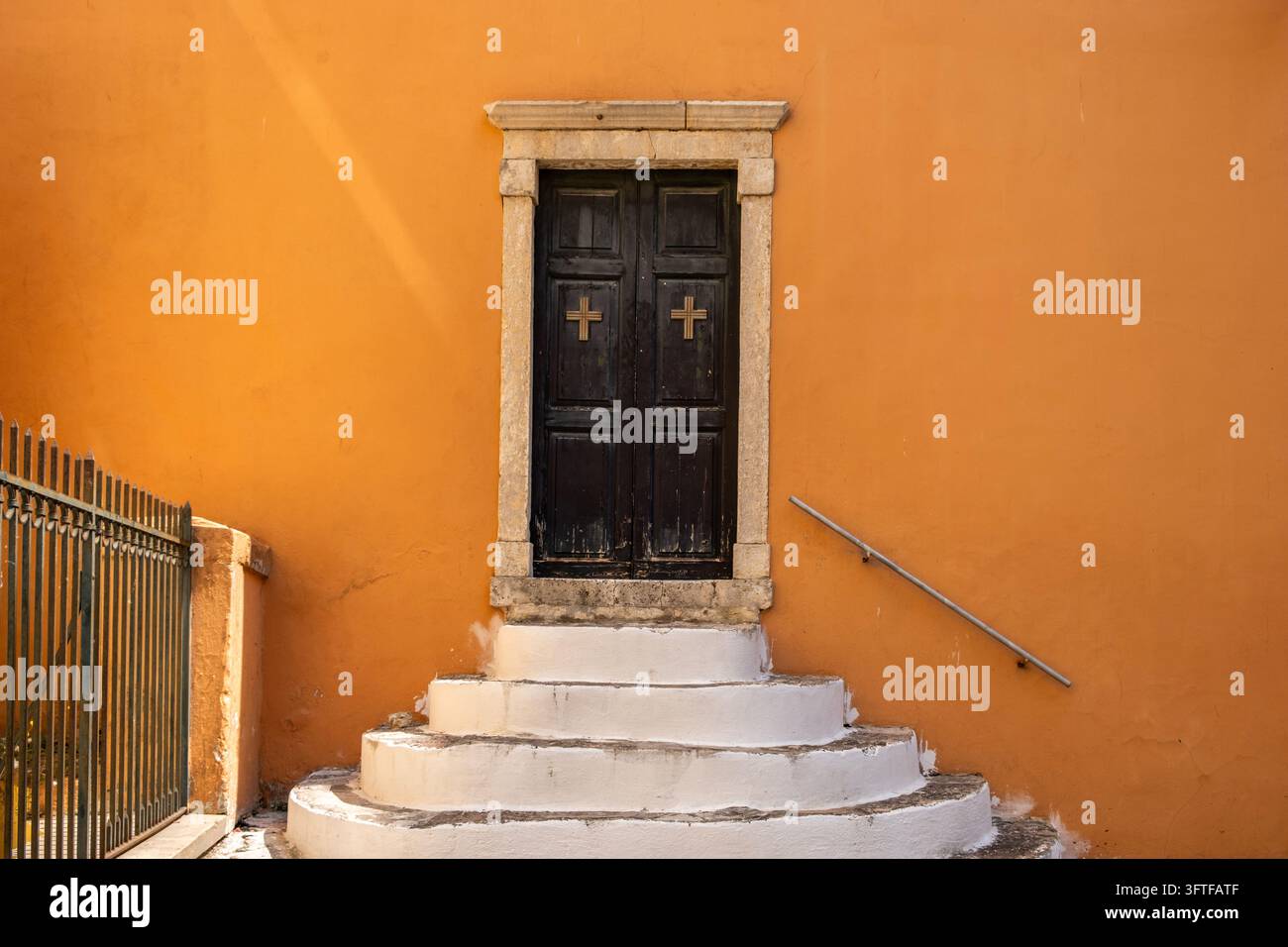 Step 6 Square Side entrance of Panagia Kremasti church with black wooden doors, white ...