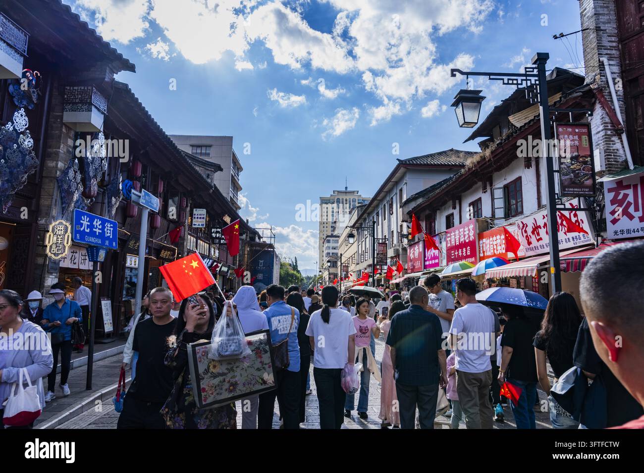 Visitors and locals crowd Kunming Old Street, where five-star red flags ...