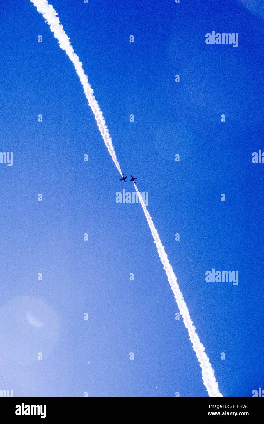 Thrailing Two display jets crossing head-on at high altitude, trailing white ...