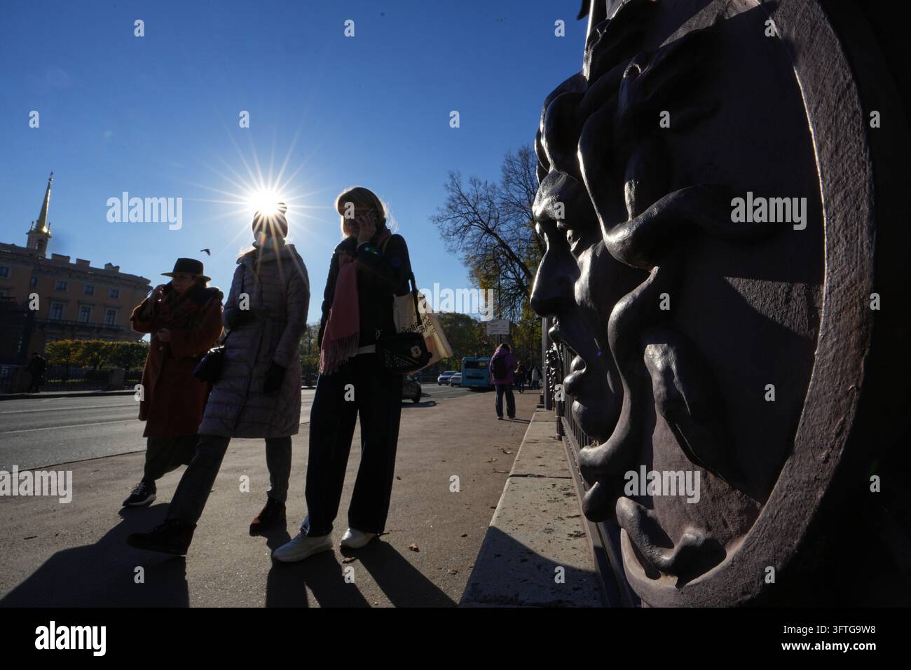 People walk past a fence with a bas-relief depicting the Gorgon Medusa ...